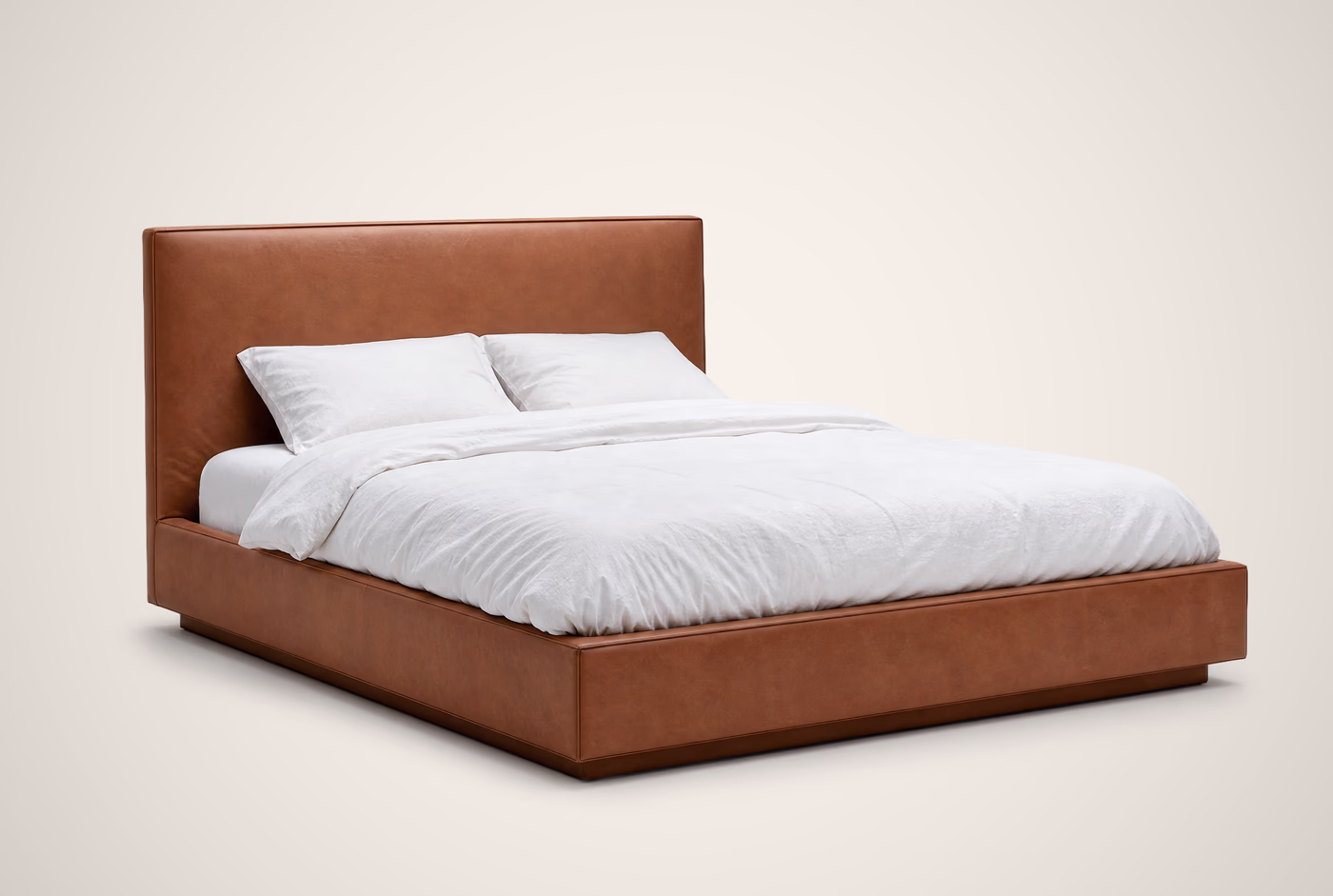 Cognac leather platform bed on a plain studio background.